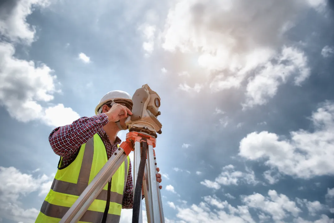 worker is surveying through tripod